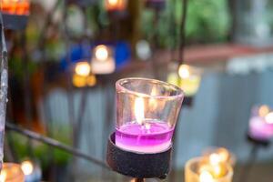 Closeup of burning candles in metal grid. photo