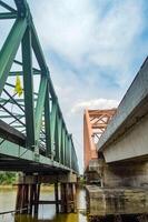 two large bridges, steel truss bridge and arch bridge, cross the river. Low Angle photo