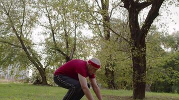 ouderen sportief Mens aan het doen Duwen omhoog opdrachten. training cardio buiten in stad park Bij ochtend- video