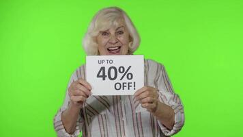 senior grootmoeder tonen omhoog naar 40 procent uit opschrift teken, verheugt kortingen, laag prijzen video