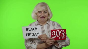 Elderly happy grandmother showing Black Friday and 20 Percent Off discount advertisement banners video