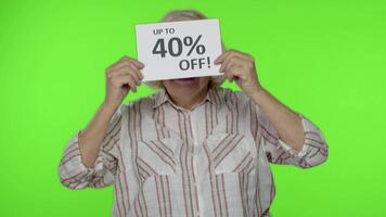 Senior grandmother showing Sale 40 percent Off banner advertisement. Online shopping. Black Friday video