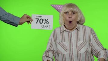 Inscription Up To 70 Percent Off appears next to grandmother. Woman celebrating with shopping bags video