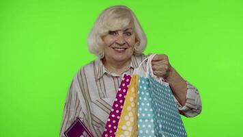 Senior grandmother showing Best Offer Sale inscription from shopping bag, rejoicing good discount video