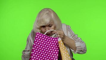 Grandmother holding shopping bags, rejoicing discounts in store, enjoying shopping with low prices video