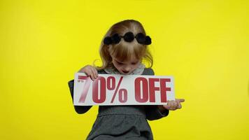 Child girl showing Up To 70 percent Off inscription low prices, advertising discounts, smiling video