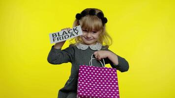 Child girl with shopping bags showing Black Friday inscription, satisfied with low prices discounts video