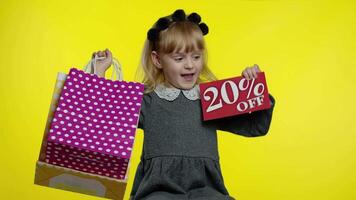 Pupil blonde girl with shopping bags showing 20 percent Off banner text advertisement. Holiday sale video