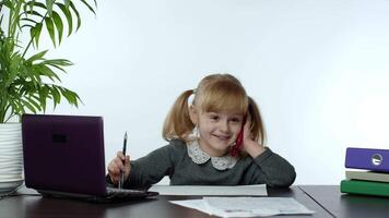 Funny little child girl boss manager emotionally talking on mobile phone, sitting at computer table video