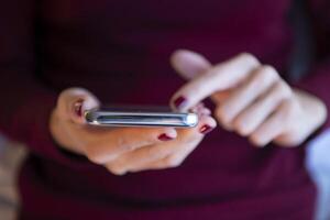 joven mujer de negocios utilizando aplicaciones en célula Los telefonos, leyendo noticias, rápido conexión en línea comunicación. foto