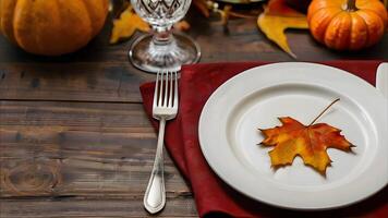 Thanksgiving autumn table setting with pumpkin and fall leaves on a rustic wooden table. Top view. photo