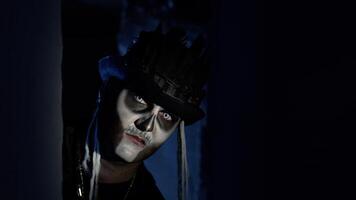 raccapricciante uomo con Halloween scheletro trucco lentamente appare a partire dal buio angolo, provando per spavento video