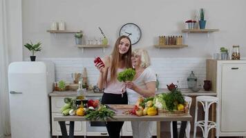 Mature woman with grandchild girl recommending eating raw vegetable food. World vegan day concept video