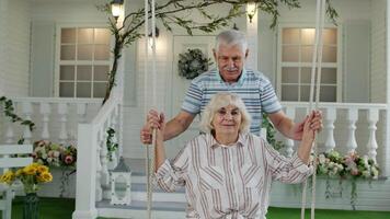 Senior Paar zusammen im Vorderseite Hof beim heim. Mann schwingen und umarmen Frau. glücklich reifen Familie video