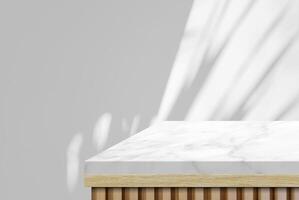 Wooden table with marble top table corner with light beam and leaves from window on wall background photo