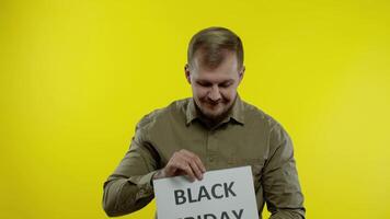 Joyful man showing Black Friday inscription note, smiling looking satisfied with low prices video