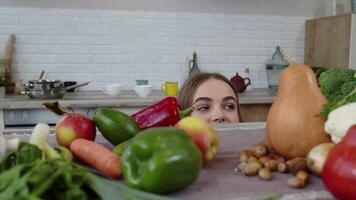 meisje piepen van onder de tafel en stelen vers appel en aan het eten het. gewicht verlies, eetpatroon concept video