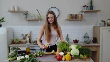 vegano menina dentro cozinha adicionando limão suco para salada com cru legumes. peso perda e dieta conceito video