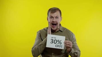 Smiling man showing Up To 30 percent Off inscriptions signs, rejoicing good discounts, low prices video