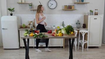 content végétalien fille avec svelte taille dansant, en chantant dans cuisine. brut légume nutrition régime concept video