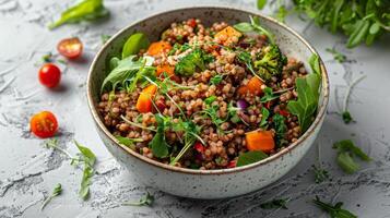 Bowl of tasty buckwheat porridge with tomato and greens on white table. Gluten free superfood. Healthy vegan food concept photo