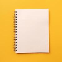 un espiral ligado blanco cuaderno en un amarillo antecedentes foto