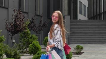 Student girl walking with shopping bags. Black Friday holiday sale discounts, low price purchases video