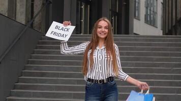 Joyful teen girl showing Black Friday inscription, smiling, looking satisfied with low prices video