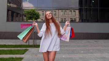 meisje met boodschappen doen Tassen, draaien, dansen, op zoek tevreden met aankoop, genieten van prijs kortingen video