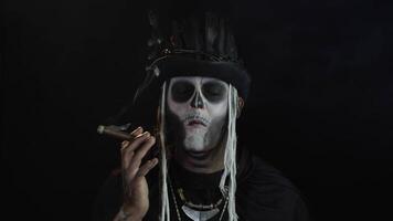 Creepy man with skeleton makeup in top-hat. Guy smoking cigar, opening his eyes, making faces video