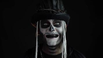 sinister Mens met schedel bedenken opening zijn mond en tonen vuil zwart tanden. halloween skelet video