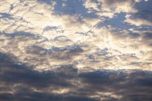azul cielo antecedentes con pequeño dorado nubes horizontal. textura foto