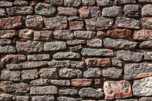 Roca textura de un pared en montenegro un antiguo pared hecho de marrón de colores piedras antecedentes. modelo. para diseño. horizontal. foto