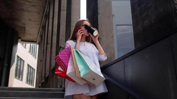 menina ficando perto compras Shopping com compras bolsas e falando em Móvel telefone sobre compras video