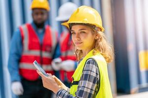 Women Engineer wears PPE checking container storage with cargo container background at sunset. Logistics global import or export shipping industrial concept. photo