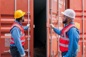 retrato de dos africano ingeniero o capataz usa ppe comprobación envase almacenamiento con carga envase antecedentes a puesta de sol. logística global importar o exportar Envío industrial concepto. foto