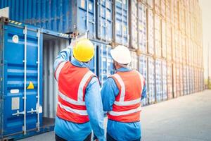 retrato de dos africano ingeniero o capataz usa ppe comprobación envase almacenamiento con carga envase antecedentes a puesta de sol. logística global importar o exportar Envío industrial concepto. foto