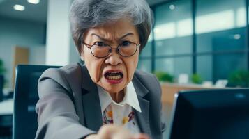 enojado antiguo asiático jefe en el oficina. retrato de furioso mujer de negocios. foto