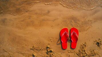Red flip flops on beach sand, top view. Summer holiday background, copy space. photo