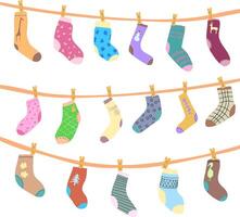 Socks of different shapes and colors hang on ropes with clothespins after washing. illustration socks and knee socks with drawings and patterns on fabric. Funny bright images with no background vector