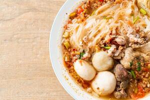 noodles with pork and meatballs in spicy soup photo