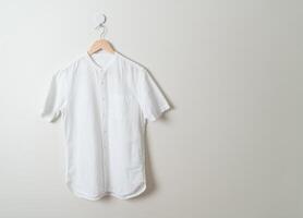 hanging shirt with wood hanger on wall photo