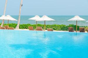 umbrella with bed pool around swimming pool with ocean sea background photo