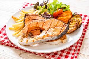 grilled salmon steak fillet with vegetable and french fries photo