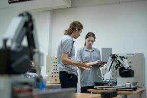 aprendiz robótica ingeniero aprendizaje con programación y manipulando robot mano, industrial robótica diseño, alto tecnología instalación, moderno máquina aprendiendo. masa producción automáticas. foto