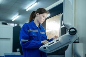 Female Robotics engineers Using Controller to Remotely Operate programming and Manipulating Robot Hand, Industrial Robotics Design, High Tech Facility, Modern Machine Learning. photo