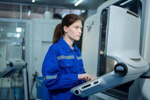 Female Robotics engineers Using Controller to Remotely Operate programming and Manipulating Robot Hand, Industrial Robotics Design, High Tech Facility, Modern Machine Learning. photo