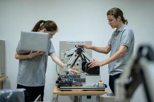 aprendiz robótica ingeniero aprendizaje con programación y manipulando robot mano, industrial robótica diseño, alto tecnología instalación, moderno máquina aprendiendo. masa producción automáticas. foto