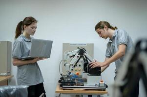 aprendiz robótica ingeniero aprendizaje con programación y manipulando robot mano, industrial robótica diseño, alto tecnología instalación, moderno máquina aprendiendo. masa producción automáticas. foto