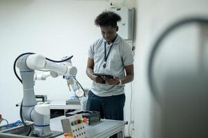 aprendiz robótica ingeniero aprendizaje con programación y manipulando robot mano, industrial robótica diseño, alto tecnología instalación, moderno máquina aprendiendo. masa producción automáticas. foto